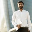 Indian business man holding laptop computer looking at camera. Successful business Indian business man holding laptop computer looking at camera. Successful business